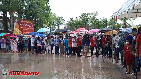 สุพรรณบุรี-กางร่มฝ่าสายฝนรอรับแจกกระบองท้าวเวสสุวรรณส่องเลขหางประทัด